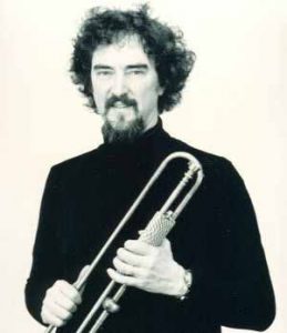 Edward Tarr holding a natural, Baroque trumpet.